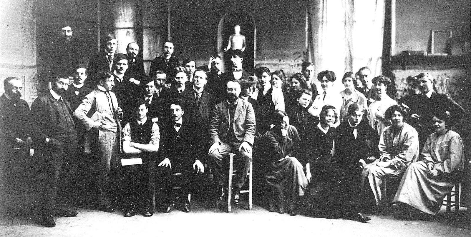Matisse pose au milieu de ses étudiants en mars ou avril 1910. La deuxième femme à droite de Matisse est Marie Vassilieff.